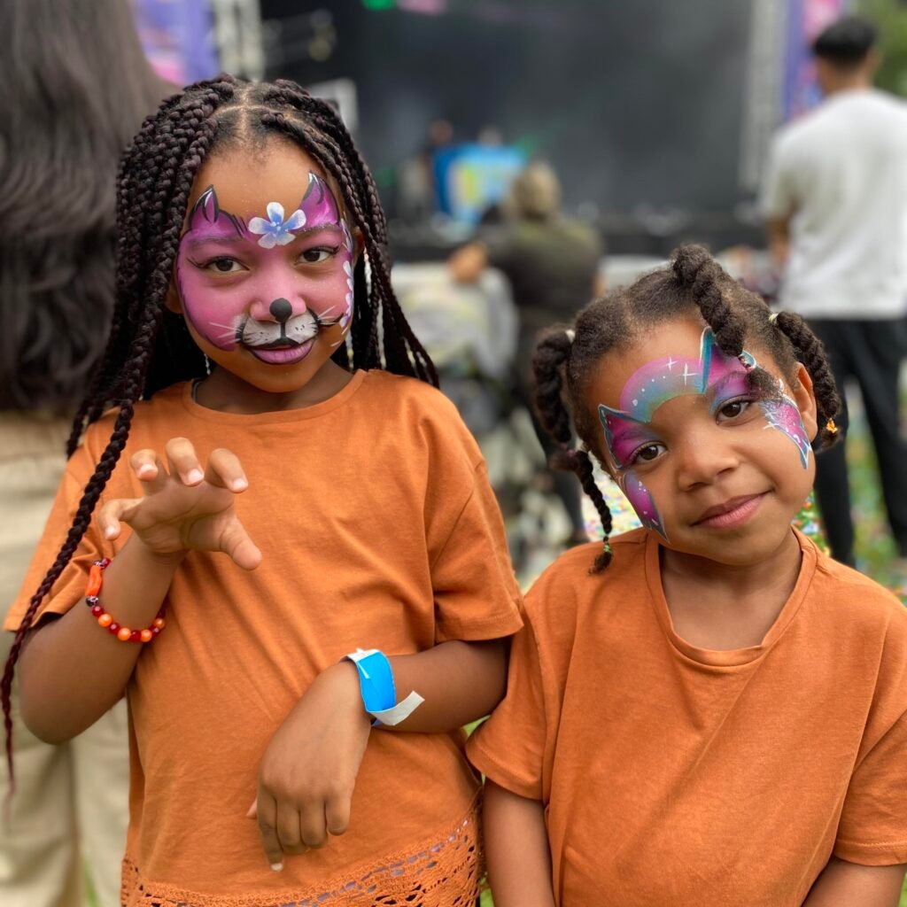 two girls with painted faces at a church carnival