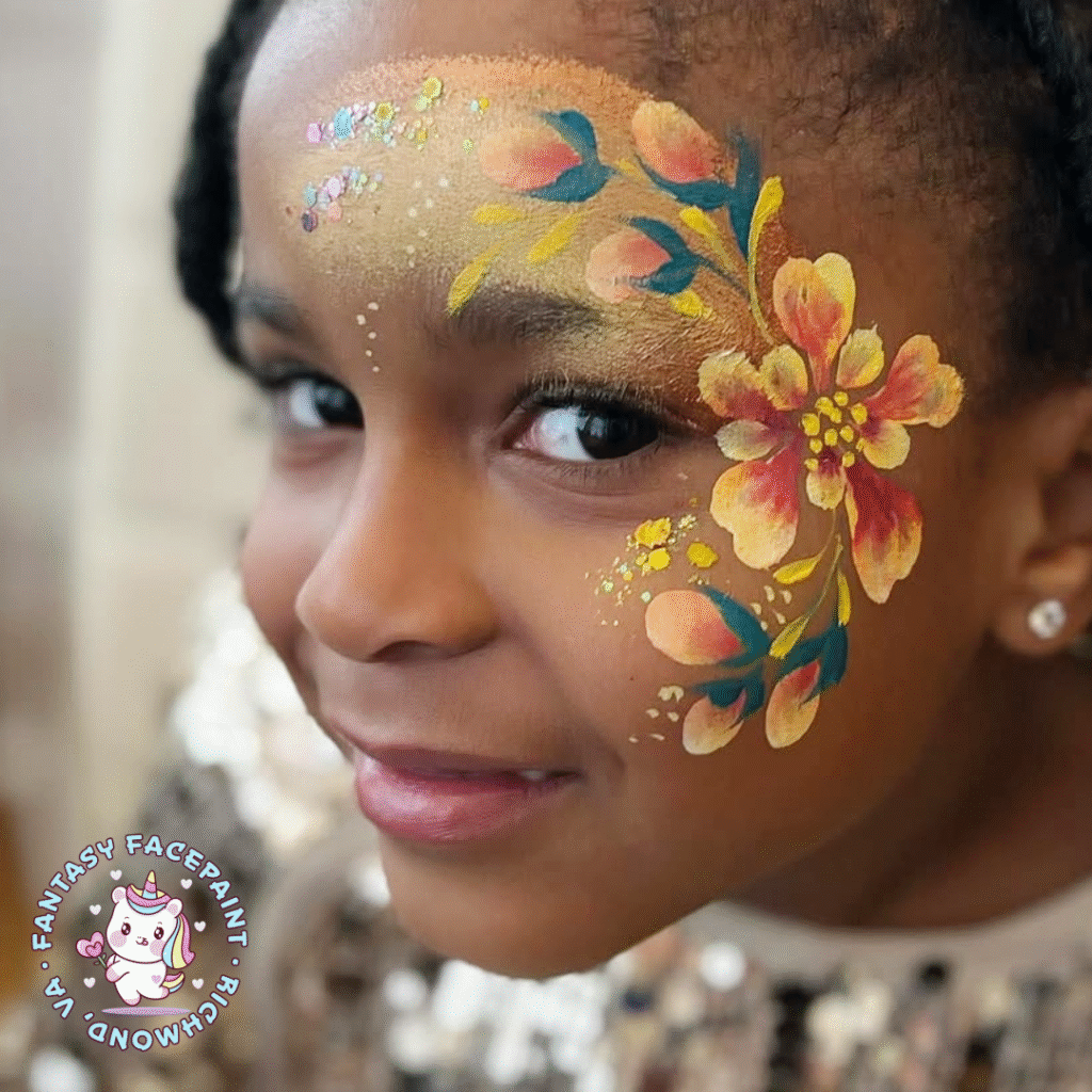 a young girl with warm brown skin shows off a fancy floral face paint design in gold, orange, and yellow shades