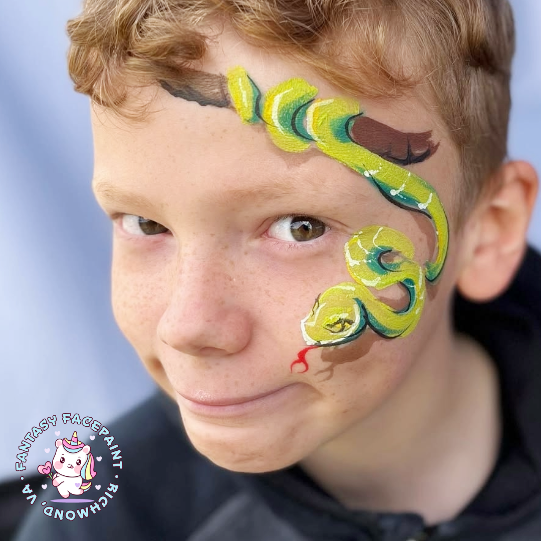snake-ffp-social A young boy smiles to show off a face paint design of a snake on his cheek and forehead